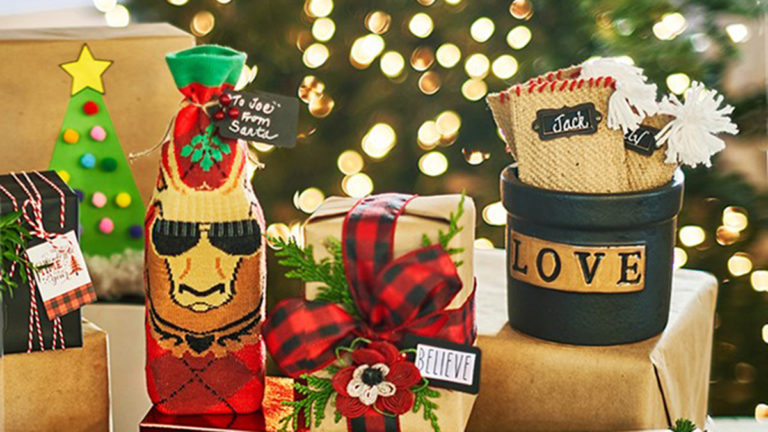 A photo of how to wrap christmas presents with several gifts in front of a christmas tree