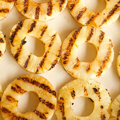 Grill pineapple slices until grill marks are visible. - Harry & David