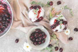 Cherry jubilee recipe with two bowls of jubilee and ice cream and a bowl of stewed cherries.