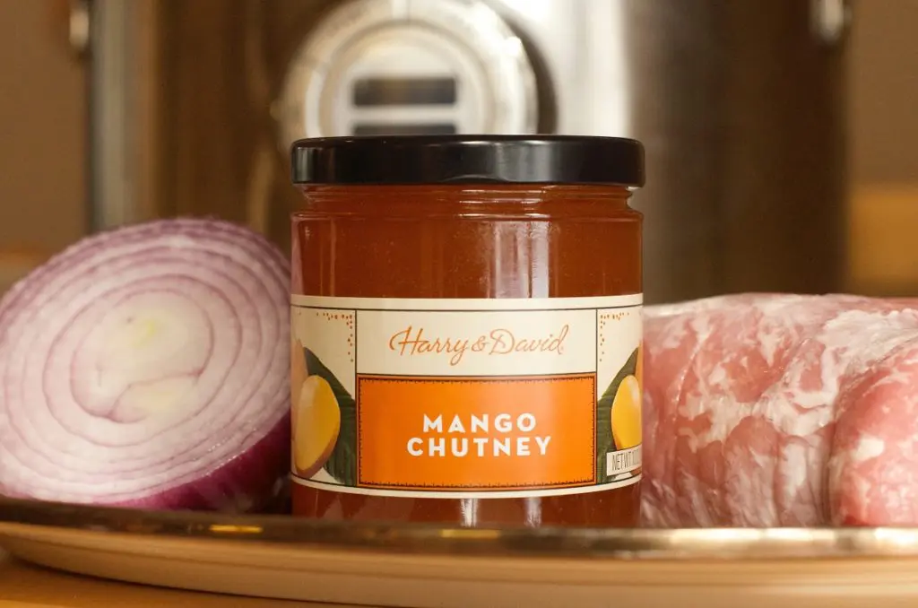 Photo of slow cooker pulled pork with a closeup of a bottle of mango chutney