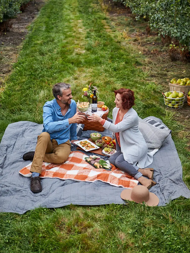 Date ideas with a couple having a picnic in a pear orchard.