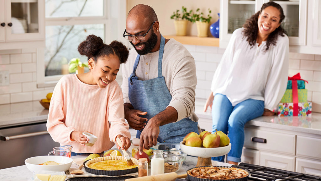 A photo of mother's day brunch ideas with a family cooking in a large kitchen