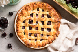 Cherry pie with a lattice top on a table.