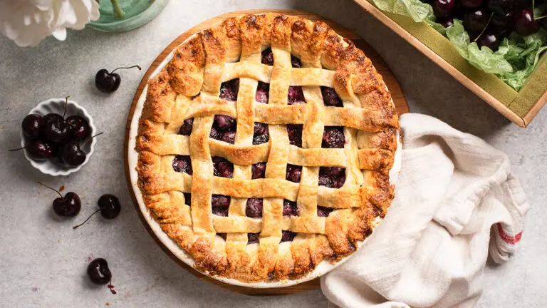 Cherry pie with a lattice top on a table.