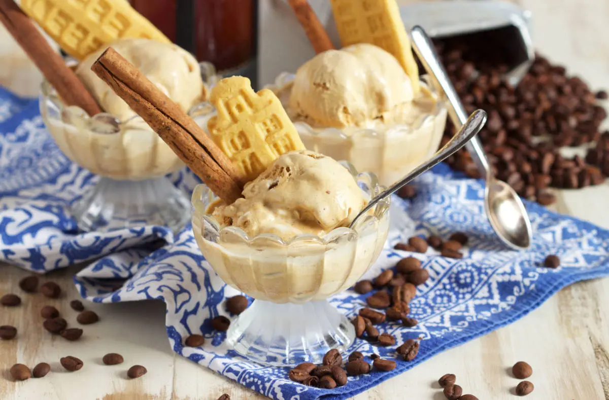 Pumpkin recipes with pumpkin affogato coffee in a bowl with a cookie and a cinnamon stick.