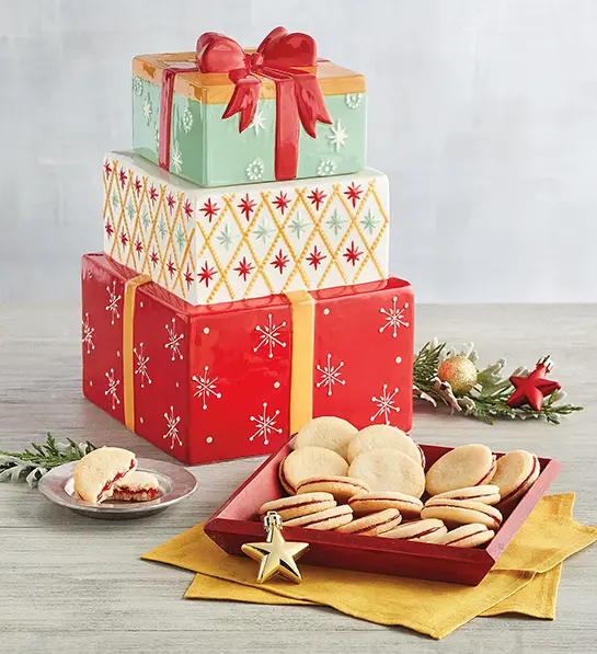 Christmas decorated cookie jar with a plate of cookies in front.