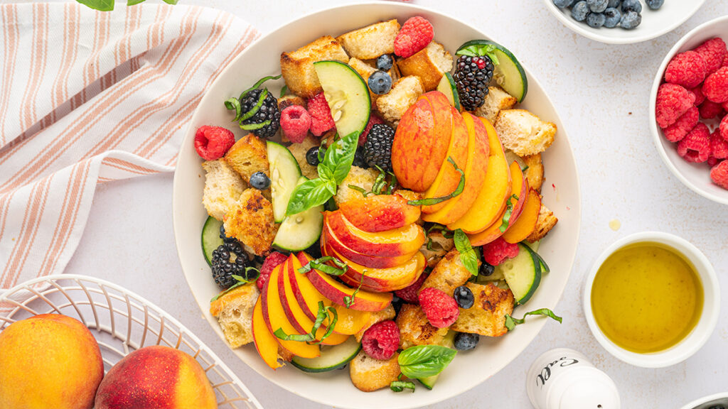 Peach panzanella salad in a bowl.