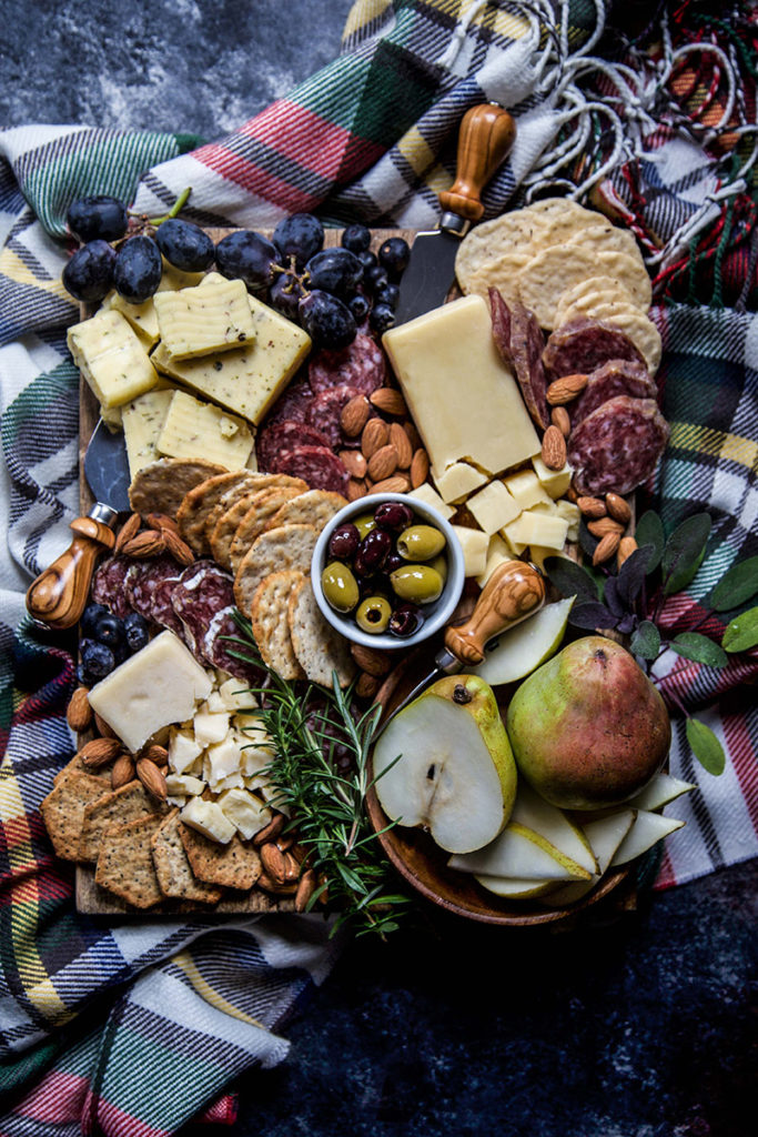 Wines for spring with a charcuterie board on top of a picnic blanket.