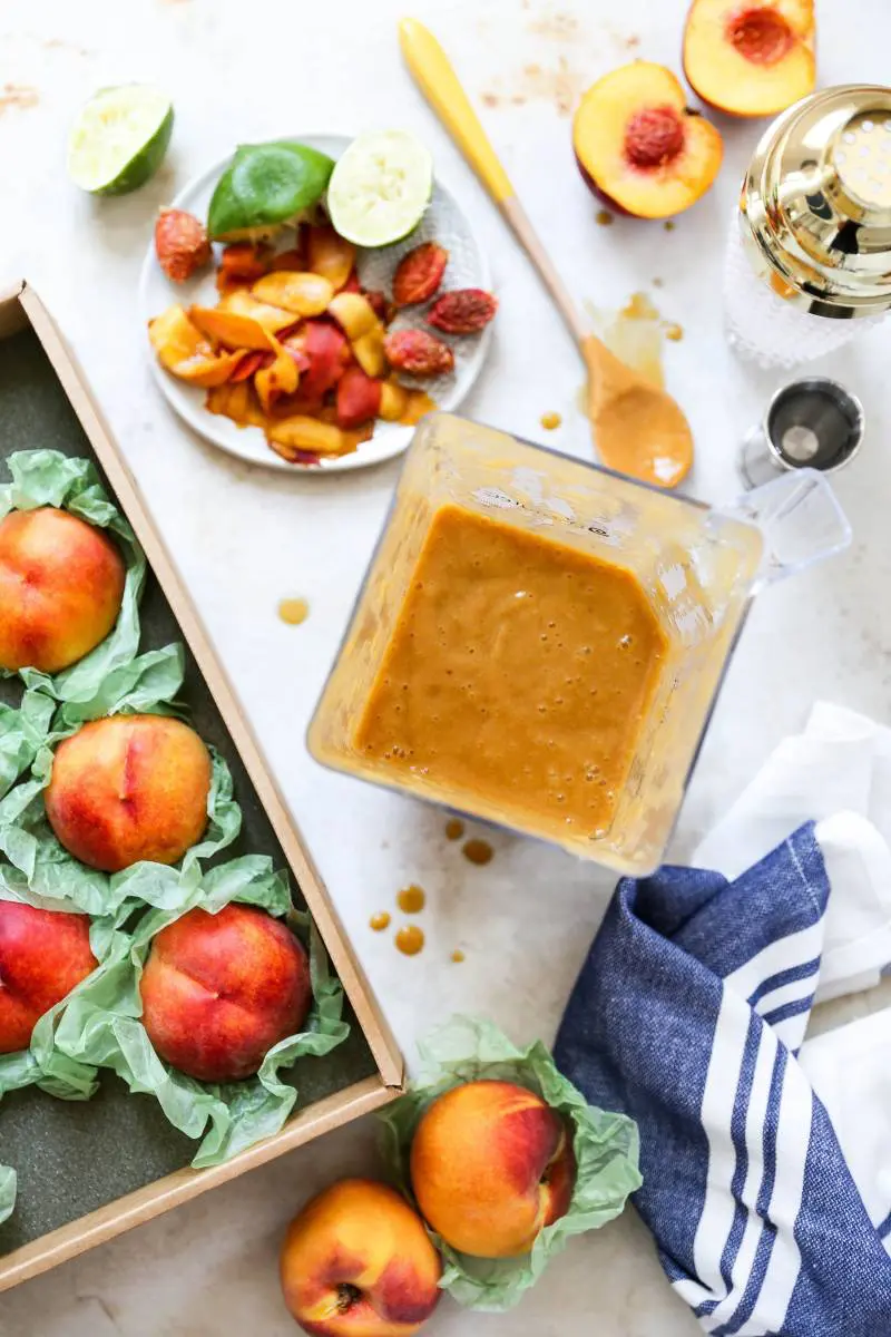 Peach margarita process with ingredients surrounding a full blender of peach puree.