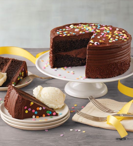 A photo of birthday gift ideas with a chocolate cake on a plate with two slices on smaller plates in front