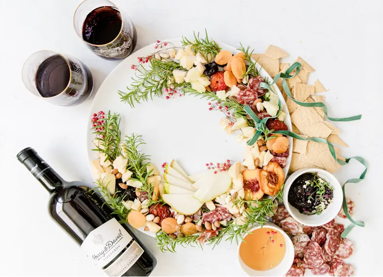 Christmas Wreath Appetizer Made with Charcuterie and Cheese and Served with Wine