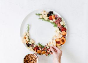 adding cheese and nuts to the holiday charcuterie christmas wreath