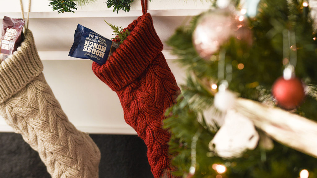 A photo of stocking stuffer ideas with two stockings hanging from a hearth