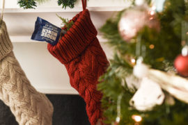 A photo of stocking stuffer ideas with two stockings hanging from a hearth
