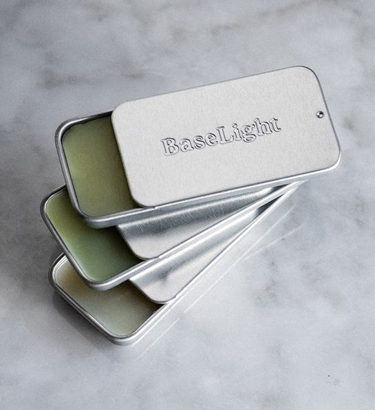 A photo of stocking stuffer ideas with a set of three solid colognes in a tin.