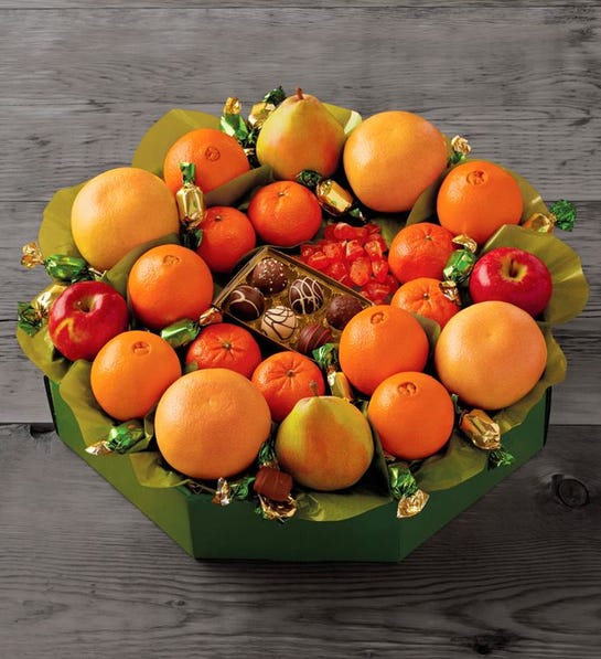 A photo of stocking stuffer ideas with a wreath of fruit and chocolates.
