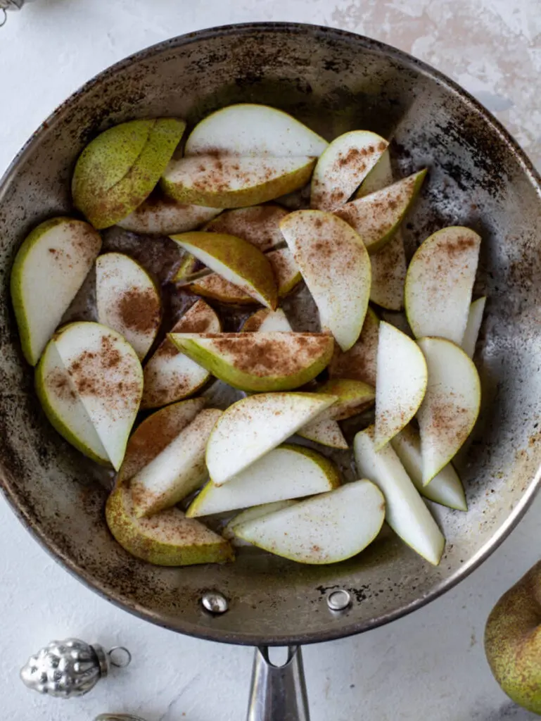 Christmas breakfast with sliced pears and spices in a pan.