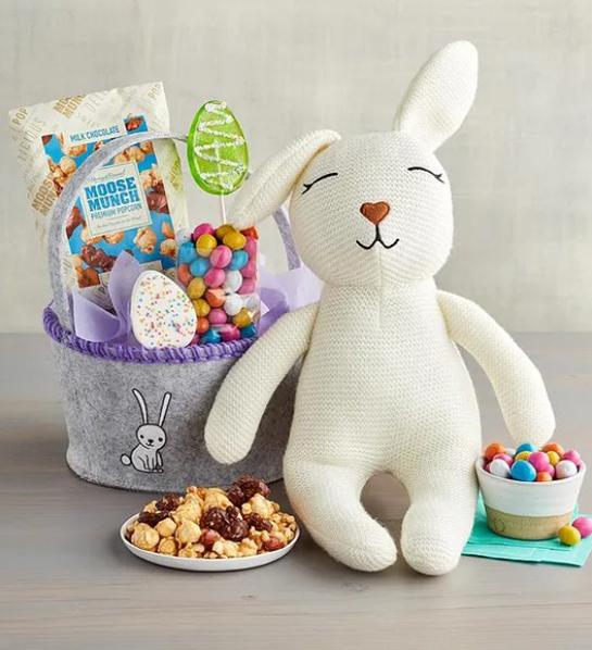 A photo of Easter gift ideas with a felt Easter basket full of Moose Munch and other candy next to a plush bunny.