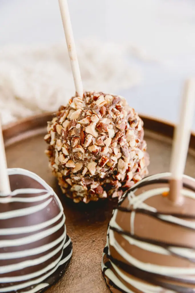 halloween snack board image - chocolate caramel-covered apples on a wooden board