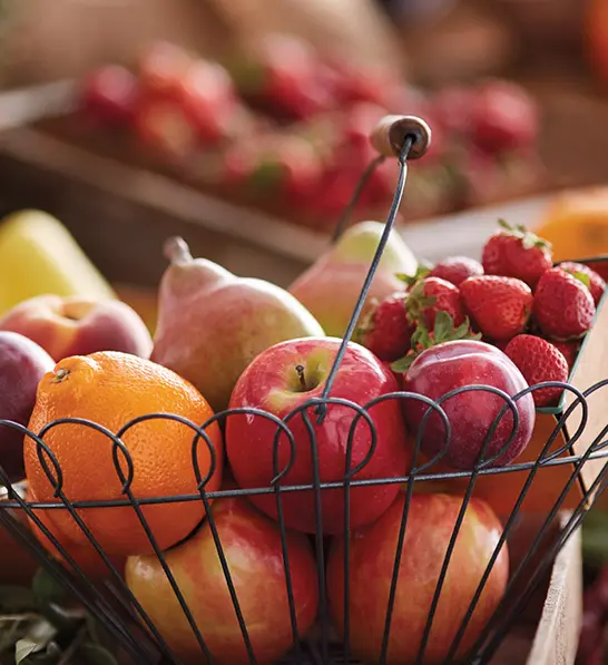 A photo of a gift guide with a basket of fresh fruit.