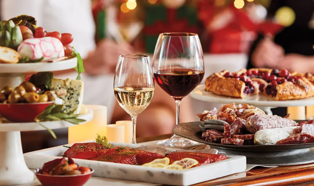 Food and wine pairings with a table full of appetizers and two glasses of wine.