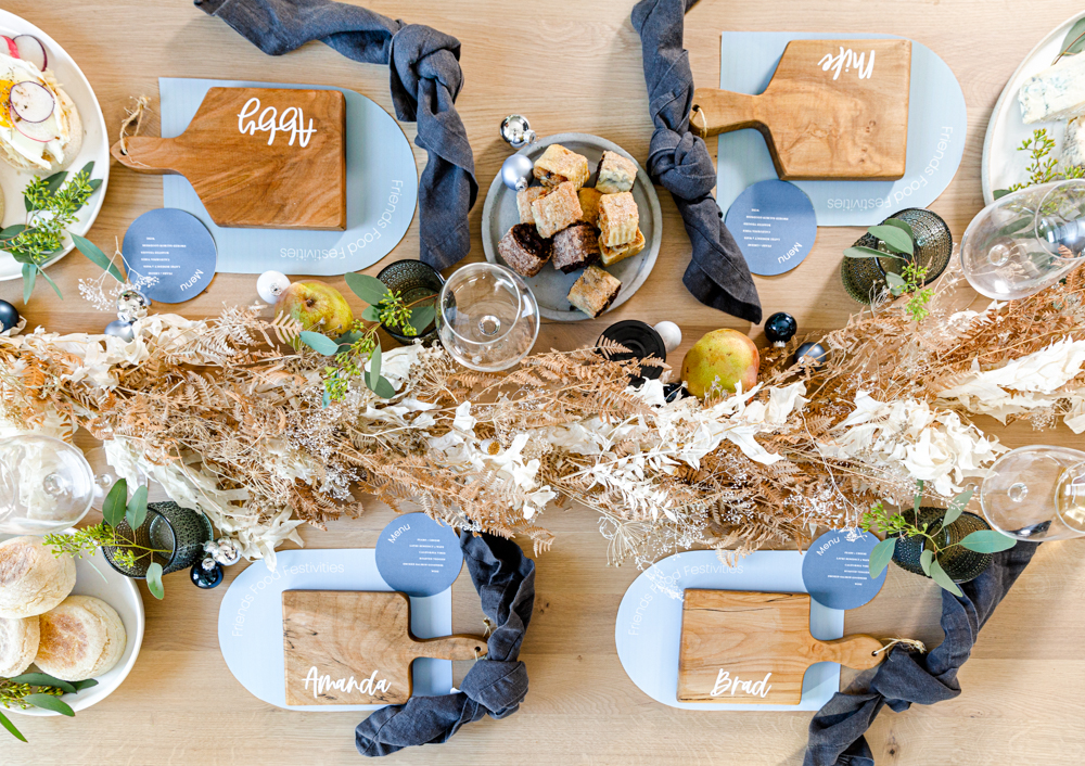 Hanukkah brunch tablescape laid with dried flowers, food and personalized placemats.