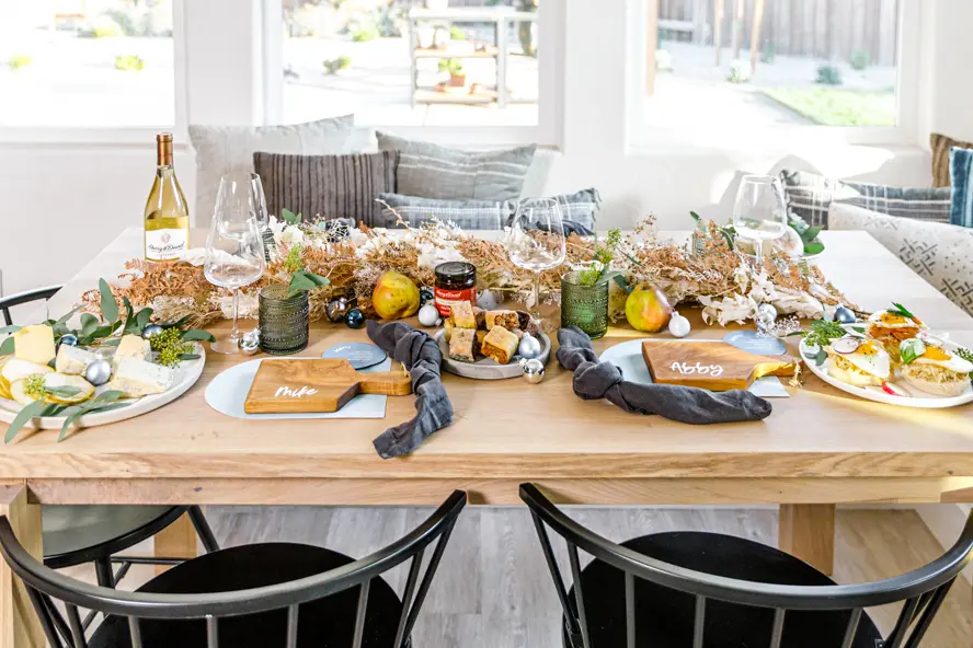 Traditional Hanukkah foods laid on a table with dried flowers and wine.