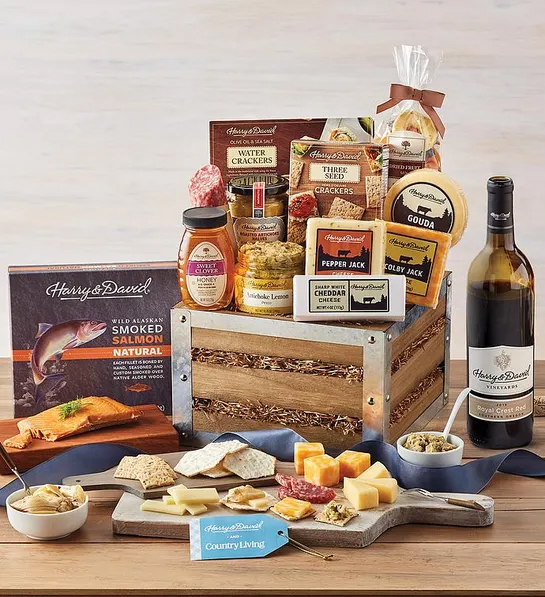 best gift basket assortment with a basket full of savory snacks next to a bottle of wine.