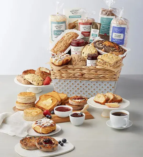 Best gift basket full of English muffins and other breakfast items surrounded by similar items on plates and platters.