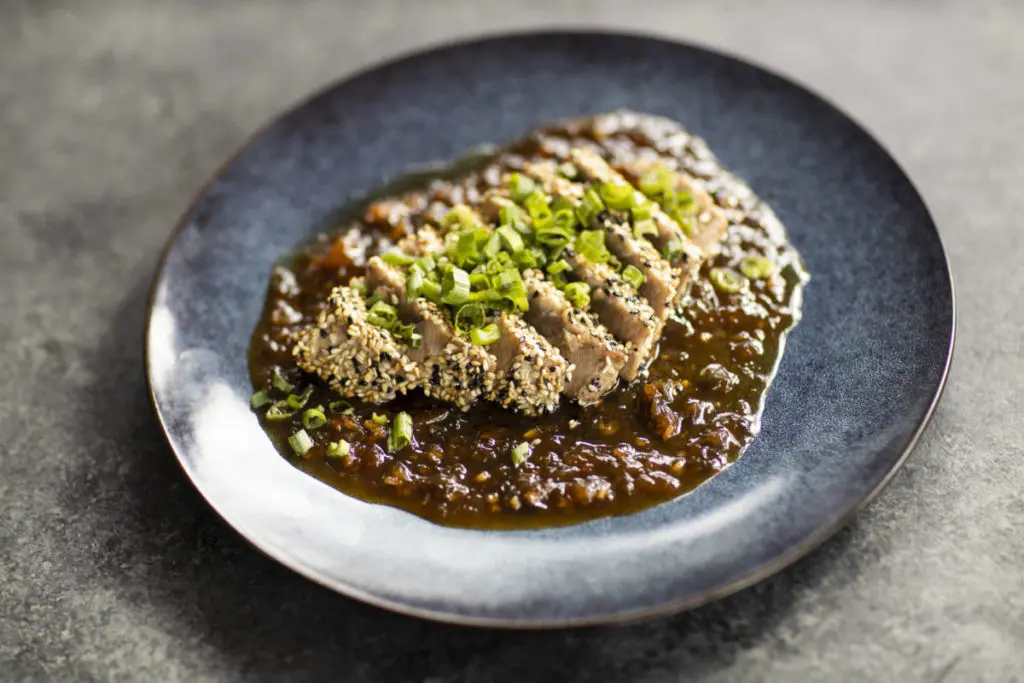 A photo of Father's Day recipes with a plate of tuna steak in sauce.