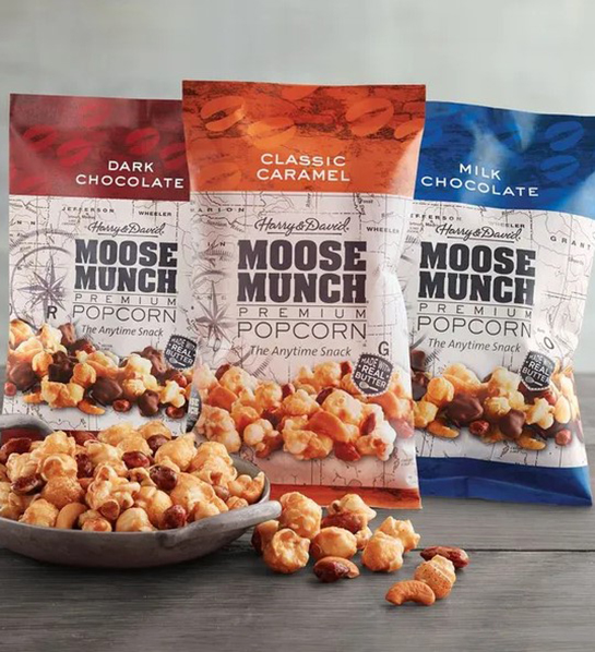 Una foto de rellenos de canastas de Pascua con tres bolsas de Moose Munch con un tazón de Moose Munch al frente.