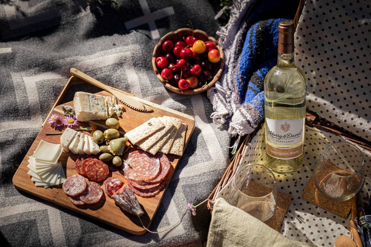 Wine for spring with a picnic spread of charcuterie, cheese, fruit, and wine.