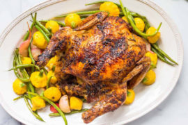 A photo of chicken recipes with a roast chicken on a bed of roast vegetables