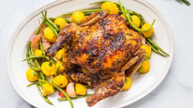 A photo of chicken recipes with a roast chicken on a bed of roast vegetables