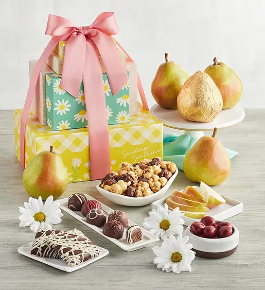 Mother's Day gift ideas with a tower of colorful gift boxes surrounded by pears, chocolate, and other treats.