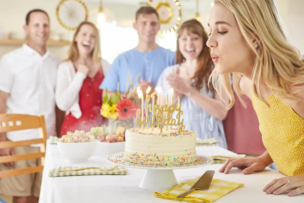 August birthday woman blowing out birthday candles