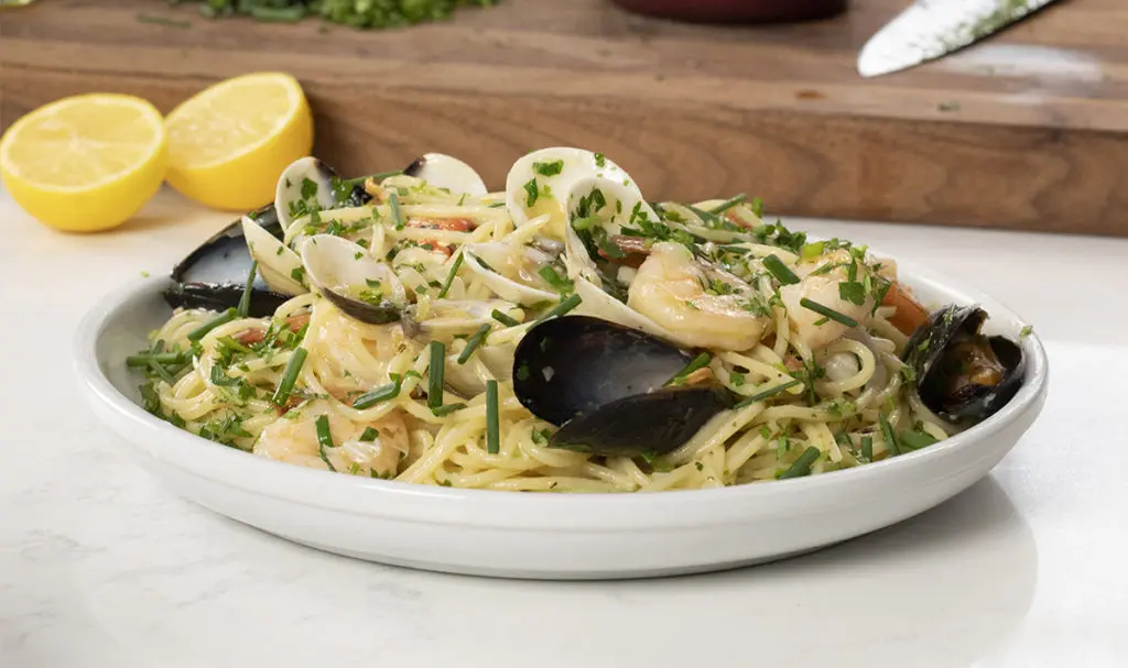 Mother's Day dinner ideas with a plate of seafood pasta on a counter.