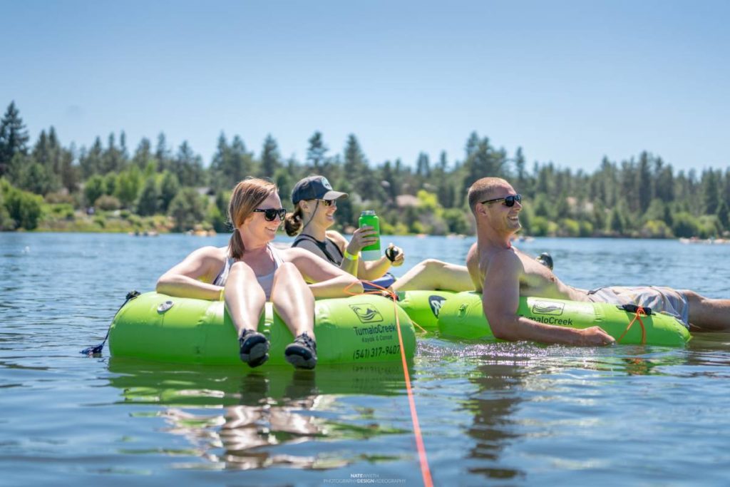 Father's Day trips with three people floating down the Deschutes river in green tubes.
