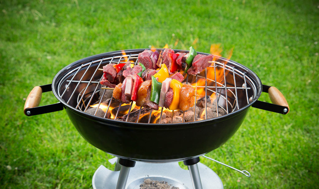 Grill guide with a charcoal grill covered with several kebabs.