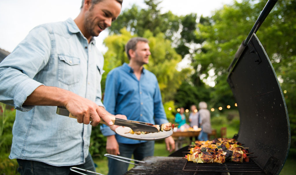 Men standing at grill