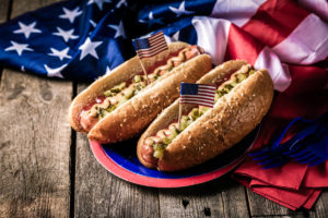 Photo of fourth o f july with a plate full of two hot dogs in buns.
