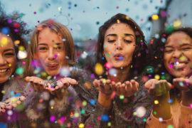 Girls blowing confetti