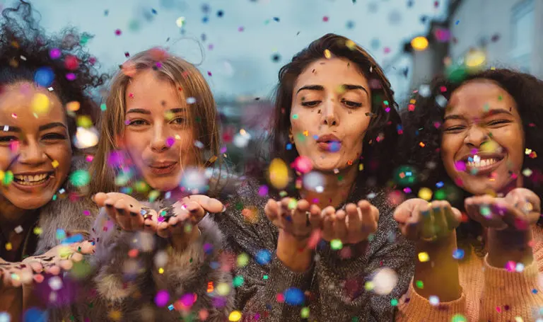 Girls blowing confetti