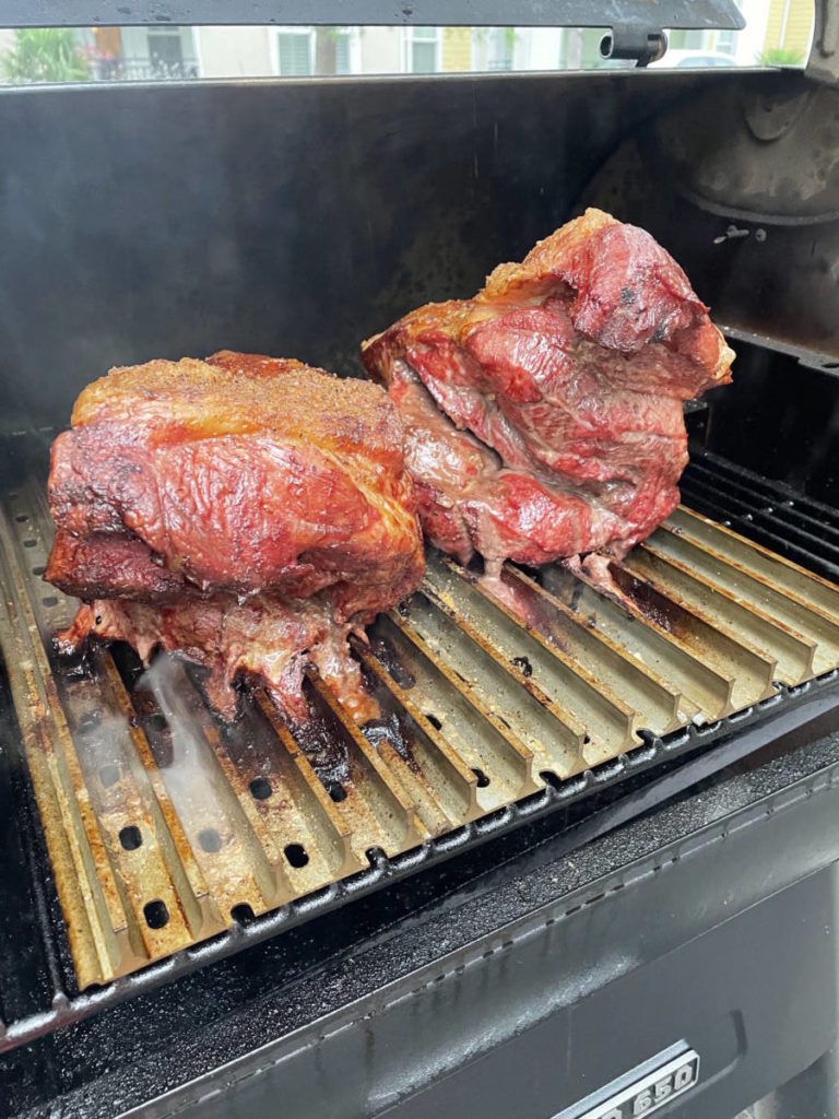 Photo of pulled pork sandwich process with pork butts on a smoker.