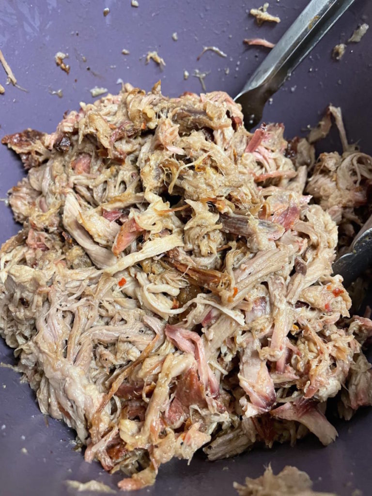 Photo of pulled pork sandwich process with a closeup of shredded pork.