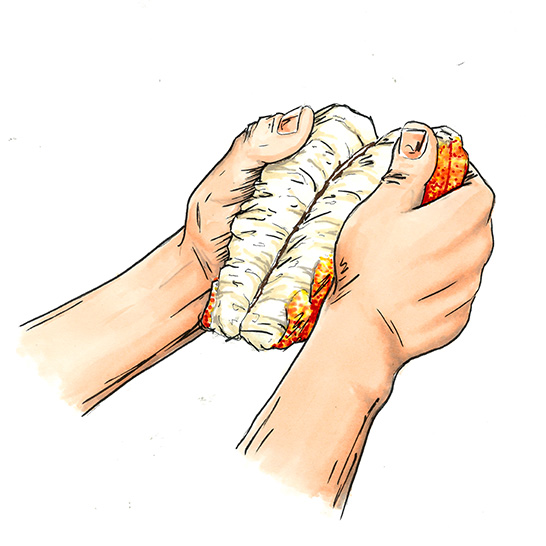 Hands removing the black vein in a lobster tail.