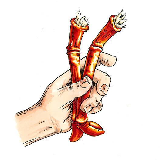 Hand holding two lobster legs.