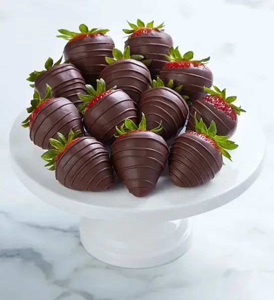 Dark chocolate-covered strawberries on a platter.