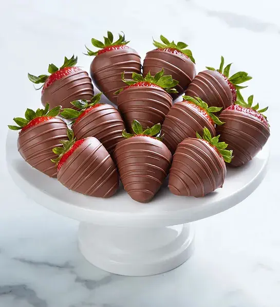 Milk chocolate-covered strawberries on a platter.
