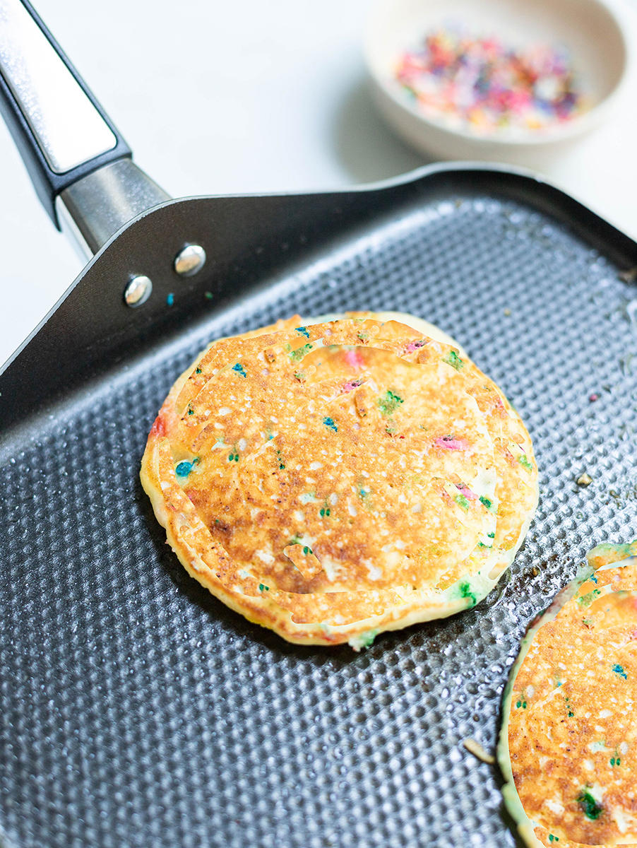 A photo of confetti pancakes being cooked on a griddle